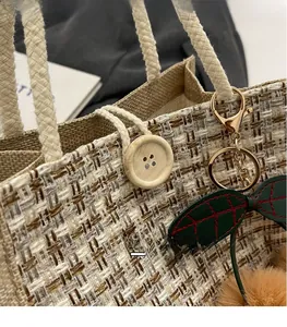 Close-up of woven linen lunch bag featuring a wooden button and cherry charm detail