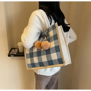 Large blue gingham tote bag with white handles and plush charm in a lifestyle setting