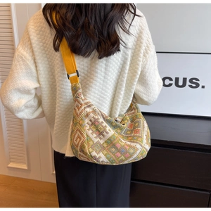 Ethnic knit crossbody bag with geometric patterns and bright yellow strap on model