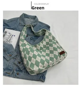 Detail of green and white argyle canvas shoulder bag on blue denim jacket background