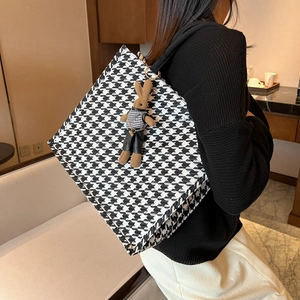 Large houndstooth tote bag with a brown rabbit plush pendant shown on a shoulder