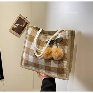 Detail of linen plaid tote bag with sturdy cotton rope handles and cherry charm decor