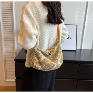 Detailed close-up of ethnic geometric woven tapestry pattern on a large crossbody bag