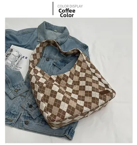 Detail of coffee brown checkerboard tote bag with leather logo tag on denim jacket