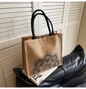 Detailed texture of jute tote bag featuring black mandala pattern and rope handles