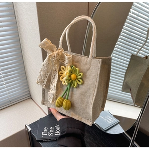 Close-up of linen mini tote with lace bow, crochet flowers and cotton rope handle
