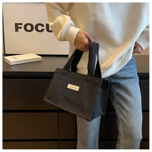 Gros plan du sac cabas en toile noire avec étiquette FASHIONS BAG en style moderne
