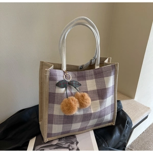 Close-up of purple plaid linen tote with rope handles and plush cherry pendant charm