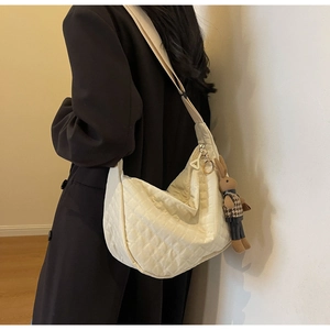 Détail du sac bandoulière matelassé en nylon beige avec un charmant lapin en peluche
