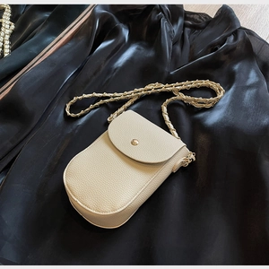 Detail der beigen Handy-Umhängetasche aus genarbtem Leder mit goldenem Verschluss