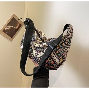 Detail of colorful geometric woven ethnic shoulder bag with adjustable black strap