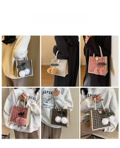 Detail of woven checkerboard tote bags with cherry pom pom charms in three colors
