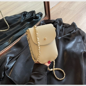 Detailansicht der beigen Mini-Tasche aus genarbtem Leder mit goldener Kette und Verschluss