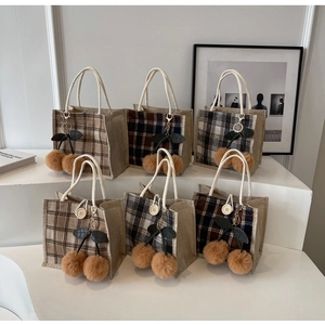 Detail showing various checkered lunch bags with cherry charms and cotton rope handles