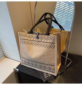 Detail of jute tote bag with black ethnic patterns and natural woven texture