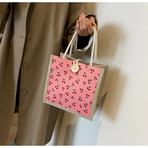 Detail of pink corduroy handbag with cherry embroidery and rustic linen base