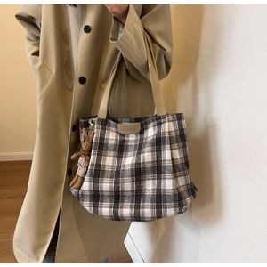Detail of wool blend plaid tote bag with FASHION leather patch and cute rabbit charm