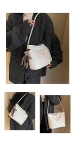 Detail of white lychee leather tote with butterfly embroidery and plush bear charm