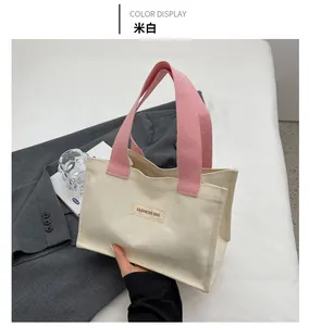 Détail du sac cabas en toile avec poignées roses et étiquette tissée FASHIONS BAG