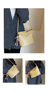 Close-up of yellow leather shoulder bag with butterfly embroidery and cute bunny charm