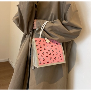 Detail of pink corduroy tote bag with cherry print and thick cotton rope handles