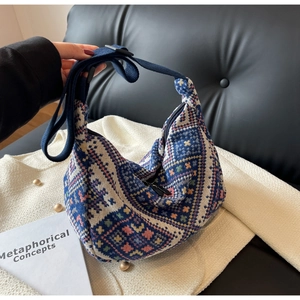 Macro detail of ethnic geometric woven fabric on a large hobo crossbody bag