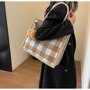 Brown and white plaid waffle tote bag with plush charm shown in a lifestyle setting