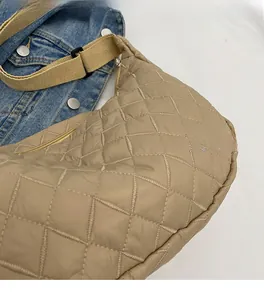 Detail of beige quilted crossbody bag with soft padded texture and adjustable strap