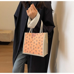 Detail of pink corduroy tote bag featuring cherry patterns and thick cotton rope handles