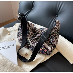 Close-up of colorful geometric woven fabric texture and adjustable strap on a shoulder bag