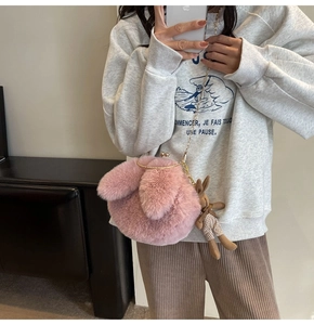 Detail of pink plush rabbit crossbody bag with gold metal clasp and chain strap