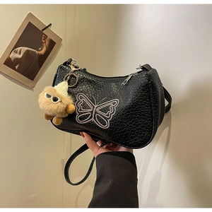 Détail du sac noir à nœud avec broderie papillon et pendentif en peluche doux