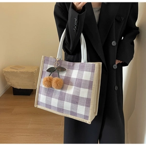 Detail of waffle pattern tote bag in purple and white with plush cherry charm decoration