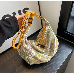 Detail of bohemian geometric woven hobo bag with yellow strap and dual zippers
