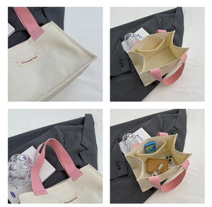Détail de l'intérieur du sac en toile avec compartiments, anses roses et étiquette