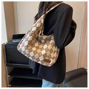 Detail of rhombic pattern canvas bag featuring a brown brand tag and large capacity