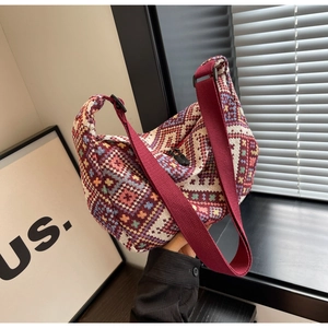Close-up of geometric ethnic pattern on large bohemian knitted crossbody dumpling bag