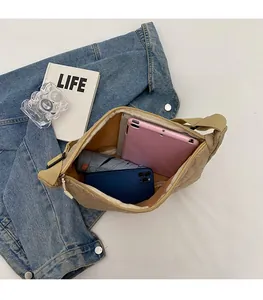 Spacious interior of beige quilted dumpling bag holding a tablet and daily items