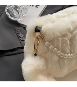 Detail of white plush faux fur texture with elegant pearl chain and gold metal clasp