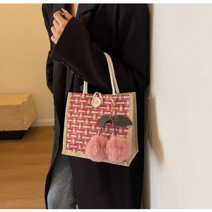 Detail of red and white tweed woven tote bag with soft cotton rope handles and cherry charm