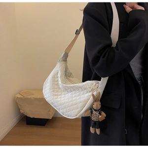 Détail du sac dumpling blanc matelassé en nylon avec porte-clés lapin en peluche