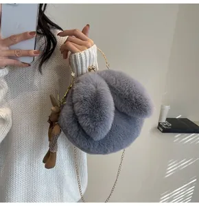 Detail of grey plush bunny bag featuring gold handles and a classic plaid rabbit charm