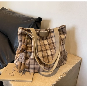 Detail view of large wool vintage plaid tote bag with fashion label and rabbit charm