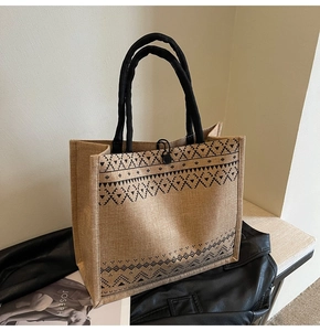 Detail of linen tote bag with geometric ethnic pattern and sturdy black fabric handle