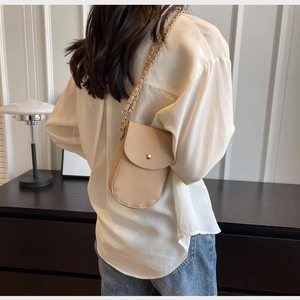Detail der beigen Handy-Umhängetasche aus Leder mit goldener Kette und U-förmigem Boden