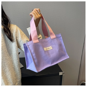 Détail du cabas en toile lilas avec poignées roses et étiquette tissée FASHIONS BAG