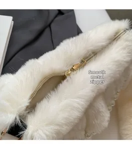 Close-up of smooth gold zipper and soft faux fur texture on elegant pearl cloud bag