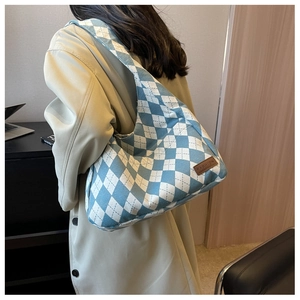 Detail of blue and white argyle knit tote bag with leather fashion tag for students