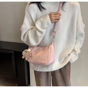 Détail du sac demi-lune rose avec texture crocodile, gaufrage papillon et charm doux