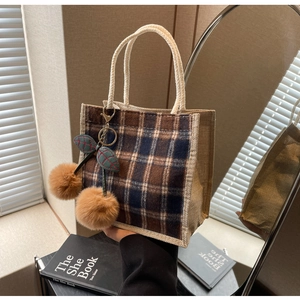 Detailed shot of retro plaid lunch bag with plush cherry charm and linen handles